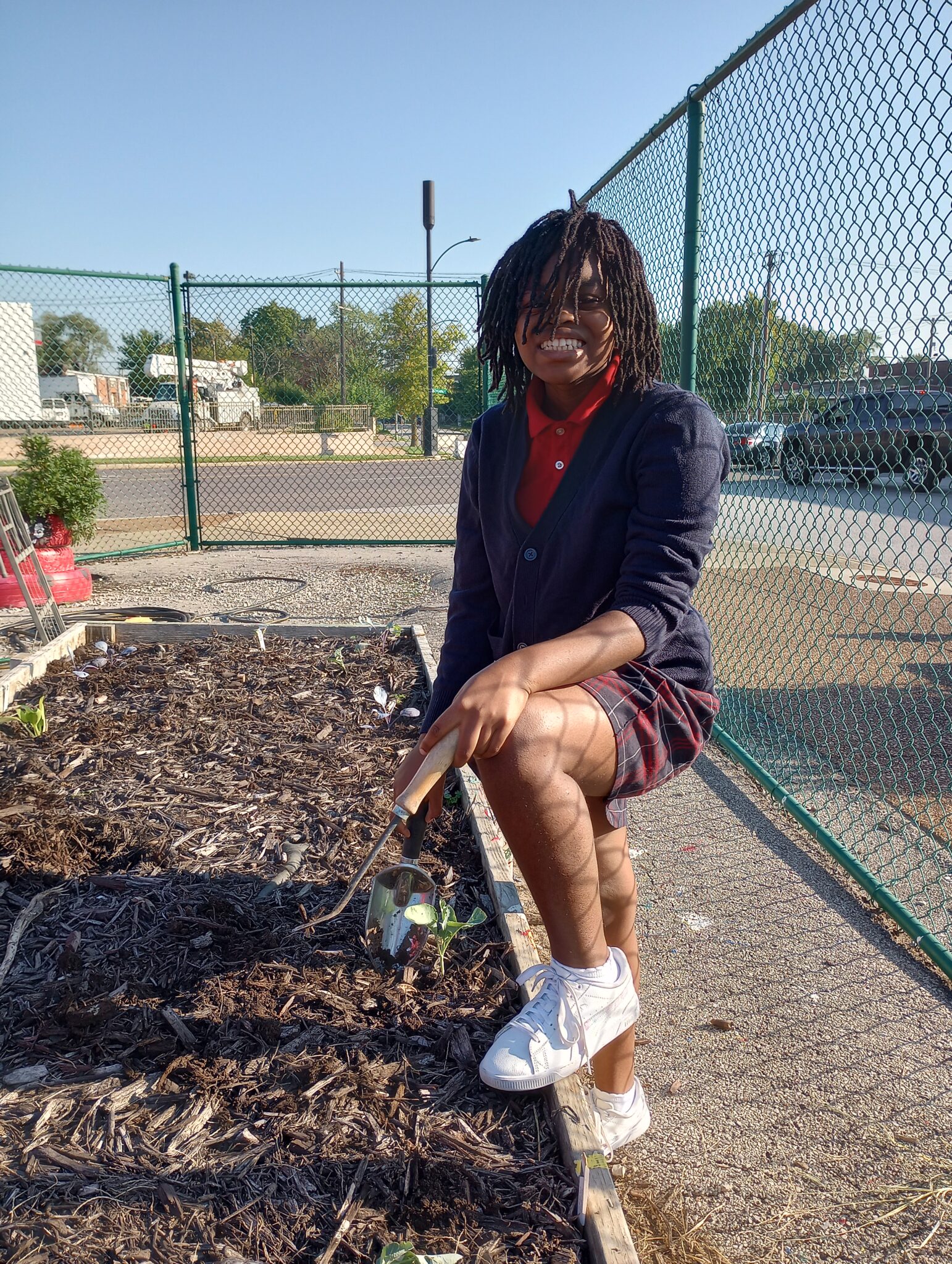 Student standing in a gardening area